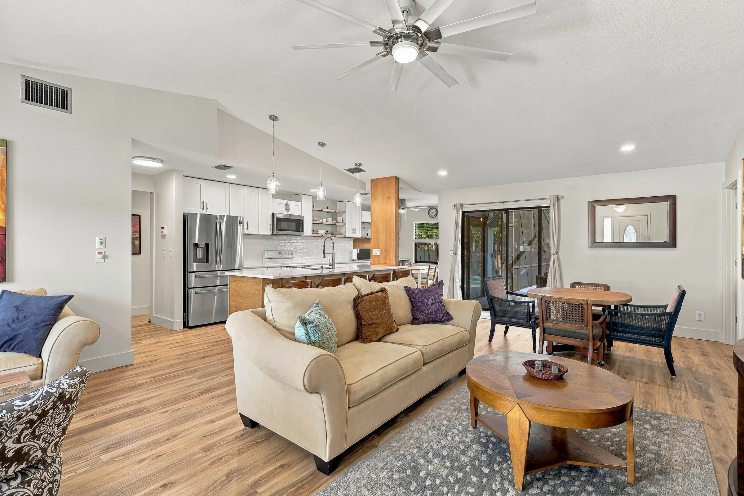 Open living room with warm wood floors photographed by Vuzario